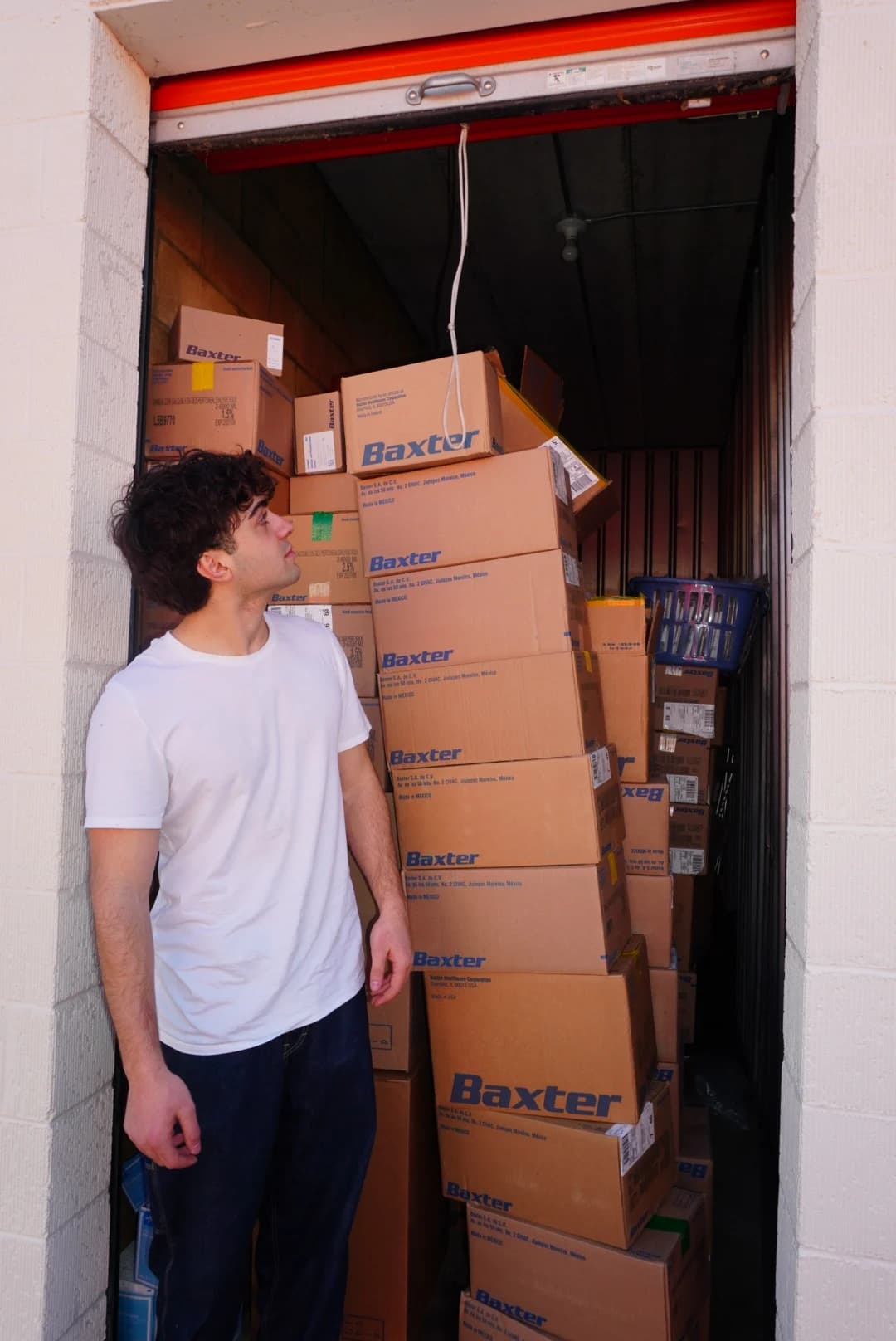 Omar Al-Tabbal beside stacked boxes of medical supplies
