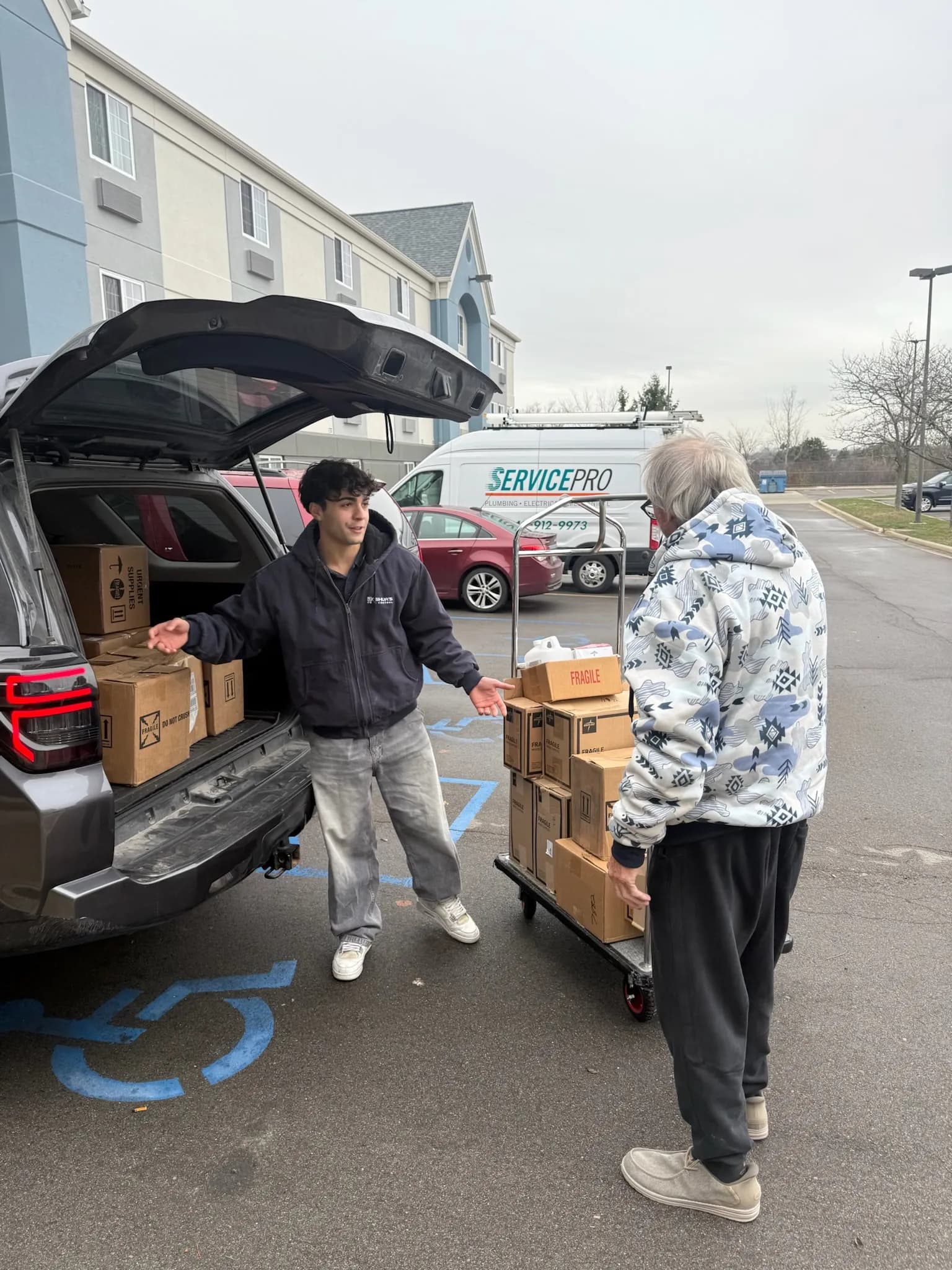 A Project Resurge volunteer collecting boxes of donated supplies from a vehicle